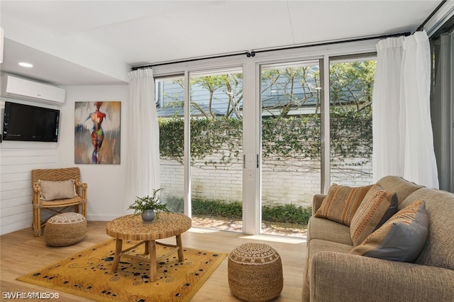 interior space with light wood-type flooring and a wall unit AC