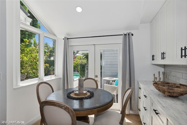 dining area with wood-type flooring, french doors, and lofted ceiling