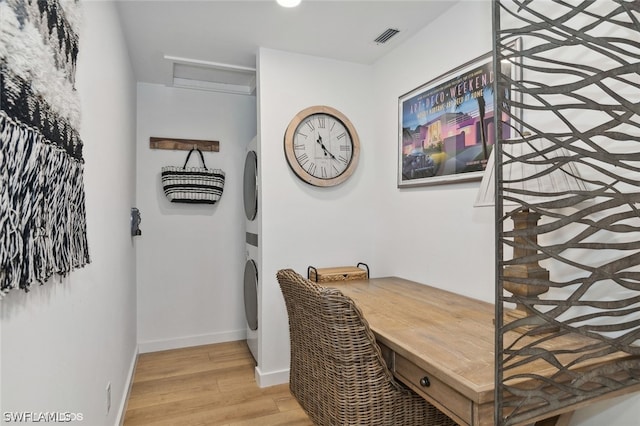 office area featuring stacked washing maching and dryer and light hardwood / wood-style flooring