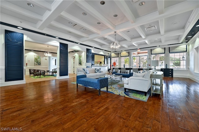 living room with beamed ceiling, dark wood-type flooring, coffered ceiling, and an inviting chandelier