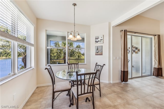 tiled dining space featuring plenty of natural light and an inviting chandelier