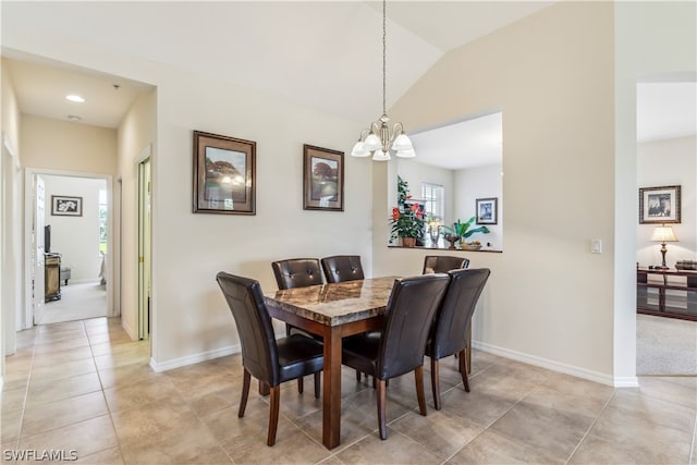 tiled dining room with a healthy amount of sunlight, vaulted ceiling, and a chandelier