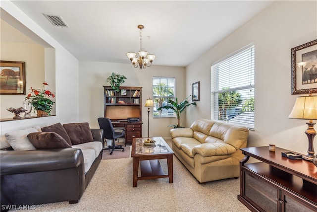 living room with light colored carpet and an inviting chandelier