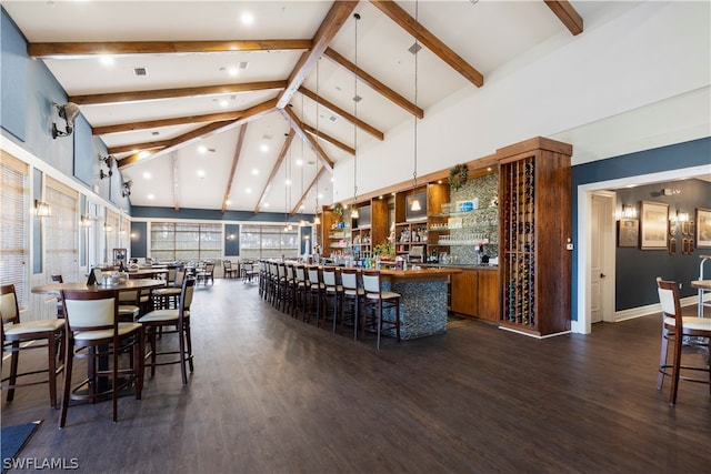 dining room featuring bar area, high vaulted ceiling, and dark wood-type flooring