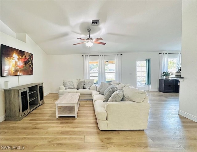 living room with lofted ceiling, ceiling fan, and light hardwood / wood-style flooring