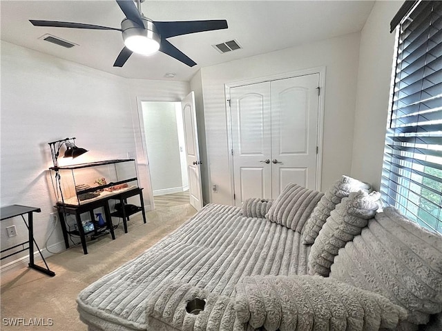 carpeted bedroom featuring ceiling fan and a closet