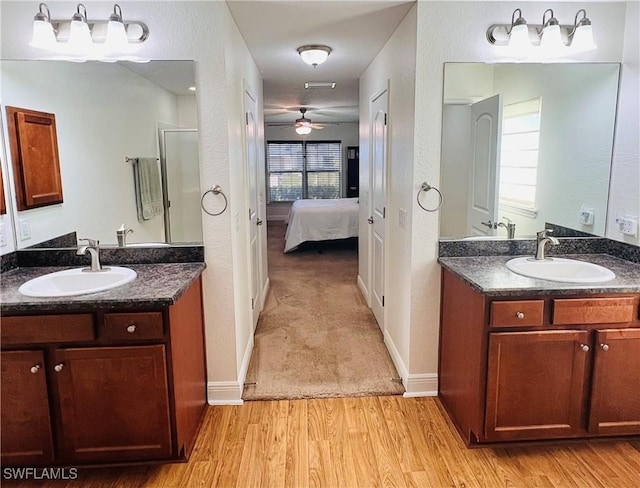 bathroom featuring a wealth of natural light, ceiling fan, vanity, and wood-type flooring