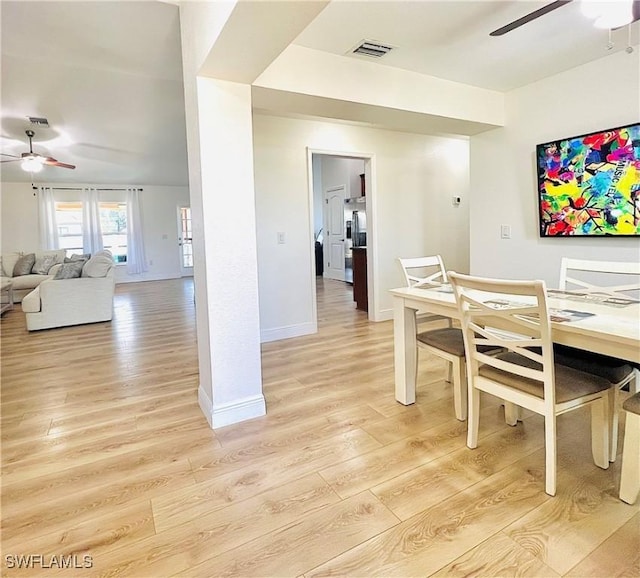 dining area with ceiling fan and light wood-type flooring