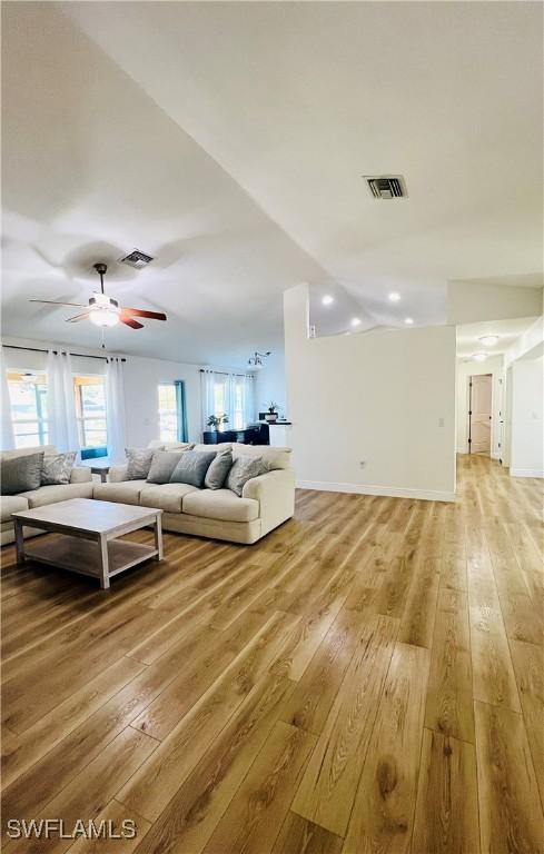 living room featuring light hardwood / wood-style flooring and ceiling fan