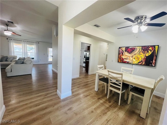 dining space with ceiling fan and hardwood / wood-style flooring