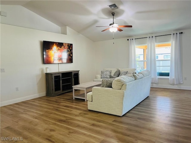 living room with ceiling fan, vaulted ceiling, and hardwood / wood-style flooring