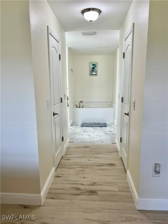 corridor featuring light hardwood / wood-style floors