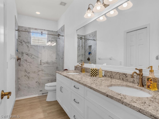 bathroom featuring toilet, hardwood / wood-style floors, vanity, and walk in shower