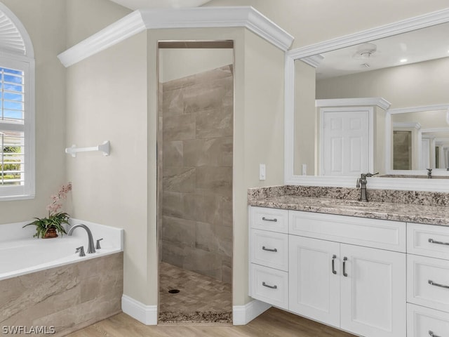 bathroom with vanity, wood-type flooring, crown molding, and independent shower and bath