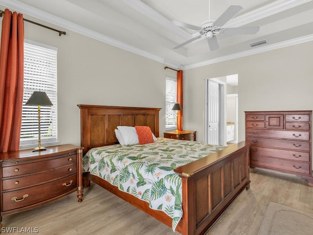 bedroom featuring light hardwood / wood-style flooring, a raised ceiling, ceiling fan, and ornamental molding