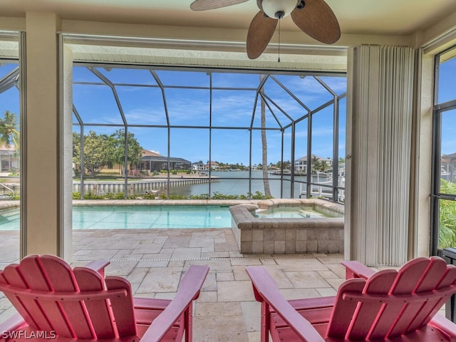 view of swimming pool featuring a lanai, ceiling fan, a water view, and an in ground hot tub