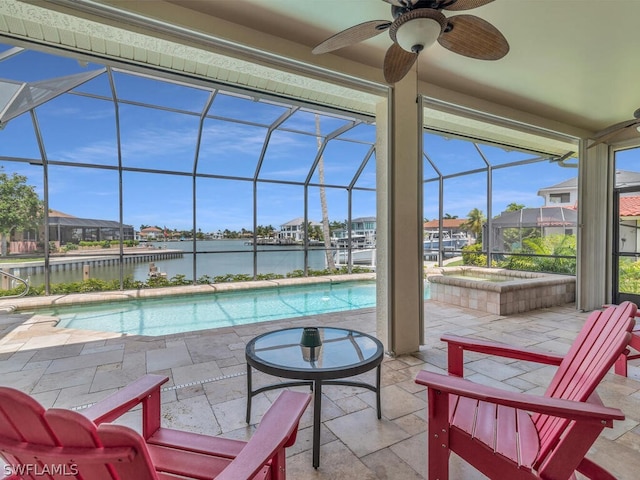 view of pool featuring glass enclosure, ceiling fan, a hot tub, a patio area, and a water view