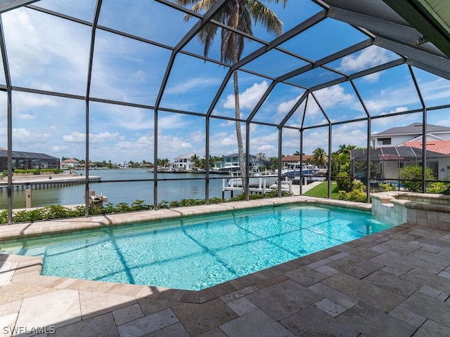 view of pool with a water view, glass enclosure, and a patio area