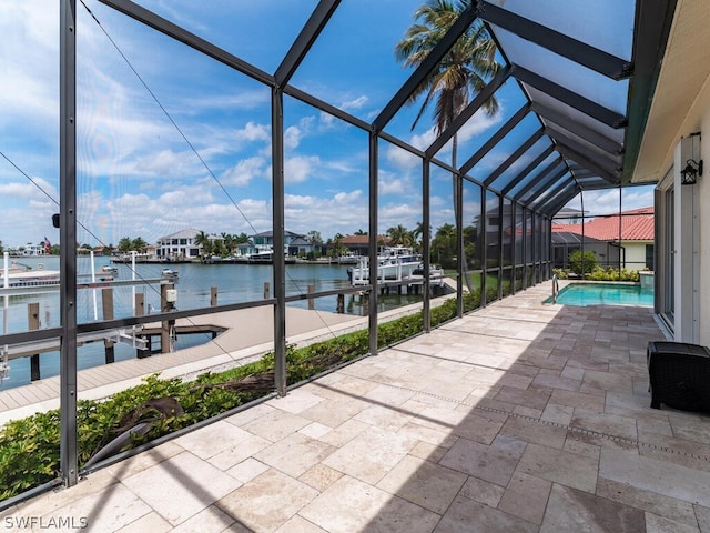 view of patio / terrace with a lanai, a dock, and a water view