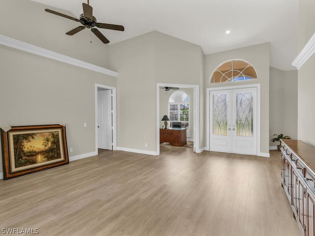 unfurnished living room featuring french doors, light hardwood / wood-style floors, high vaulted ceiling, and ceiling fan