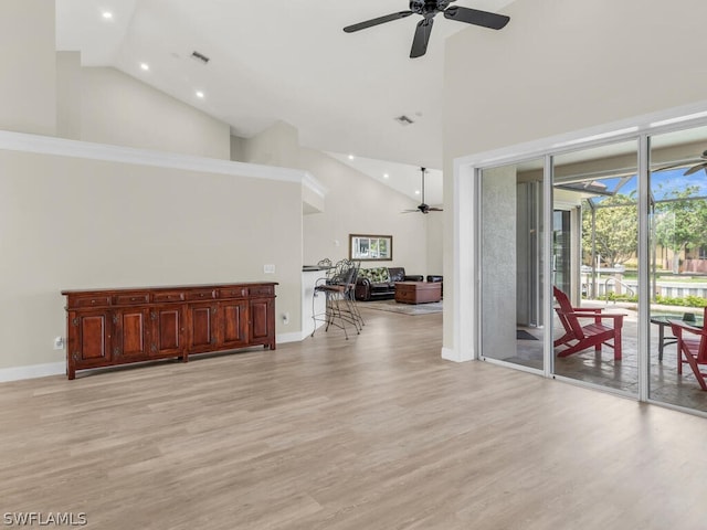 interior space with ceiling fan, light hardwood / wood-style floors, and a high ceiling