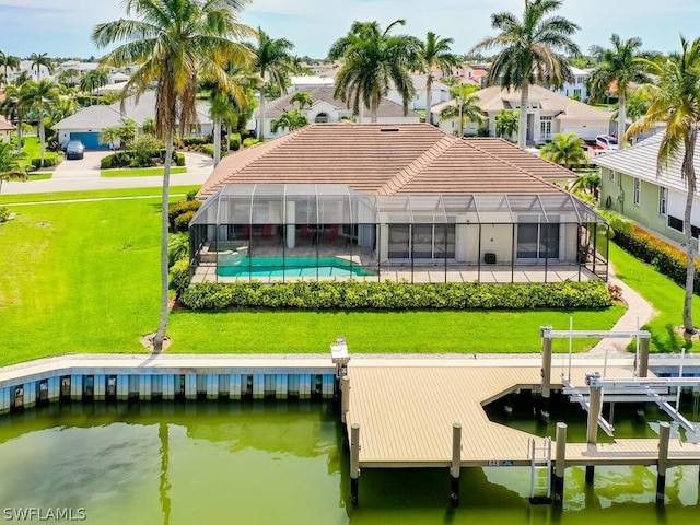 rear view of house featuring a yard, a water view, and a lanai