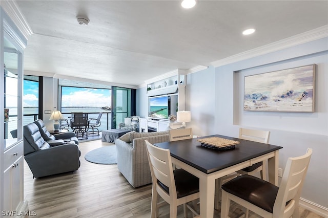 dining room featuring expansive windows, light hardwood / wood-style floors, and crown molding