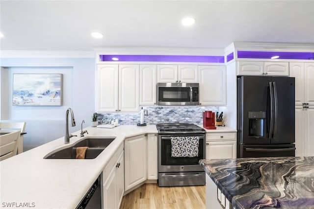 kitchen with white cabinets, light hardwood / wood-style floors, stainless steel appliances, backsplash, and sink