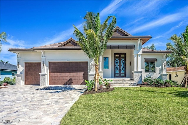 view of front of home featuring a front lawn, decorative driveway, a garage, and stucco siding