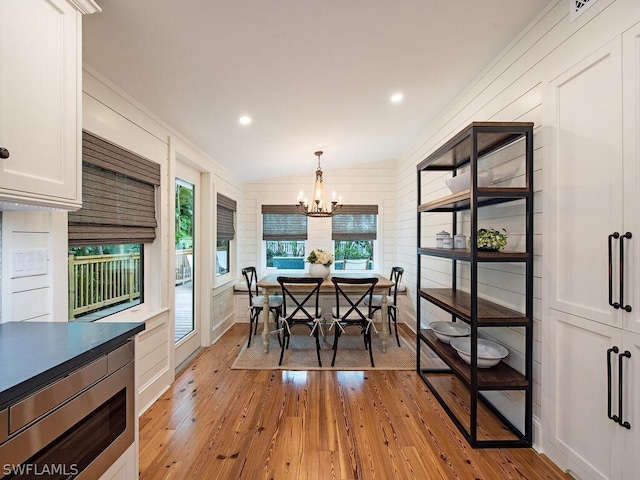 dining space featuring an inviting chandelier, ornamental molding, and light hardwood / wood-style flooring