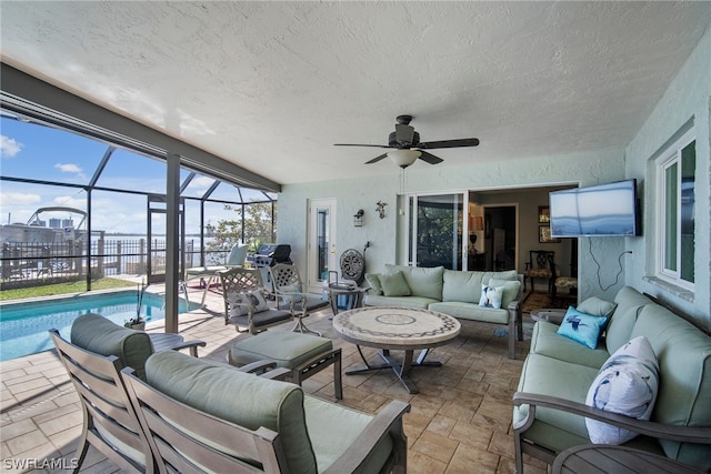 interior space with glass enclosure, outdoor lounge area, ceiling fan, and a fenced in pool