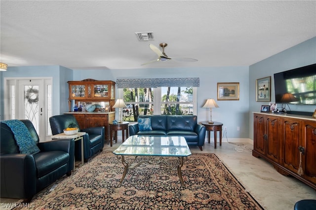 living room with a textured ceiling and ceiling fan