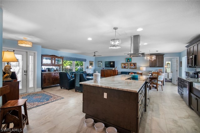 kitchen featuring appliances with stainless steel finishes, pendant lighting, a kitchen island, ceiling fan with notable chandelier, and island range hood