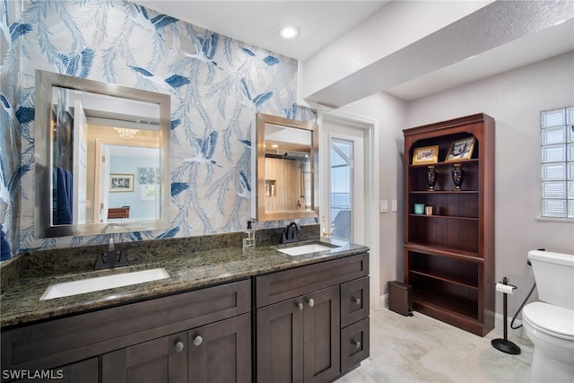 bathroom with dual bowl vanity, toilet, a wealth of natural light, and tile floors