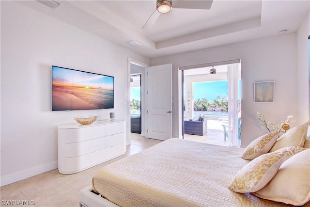 tiled bedroom featuring access to exterior, ceiling fan, and a tray ceiling