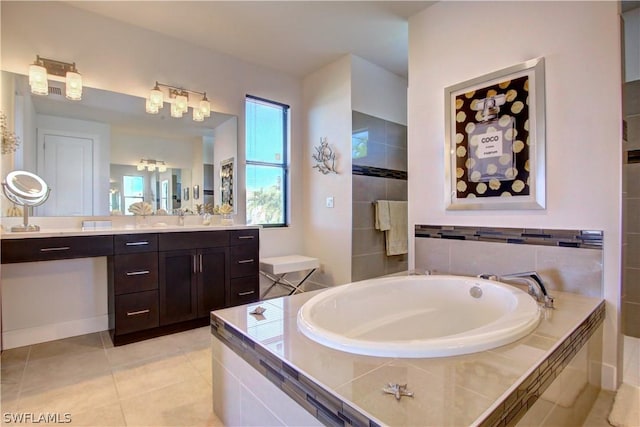 bathroom with tile patterned flooring, a relaxing tiled tub, and vanity