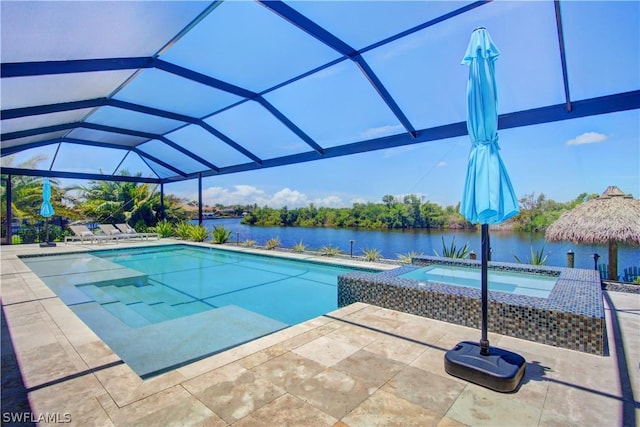 view of swimming pool with a patio, glass enclosure, and a water view