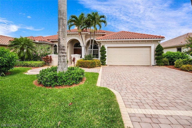 mediterranean / spanish-style home with a front lawn and a garage