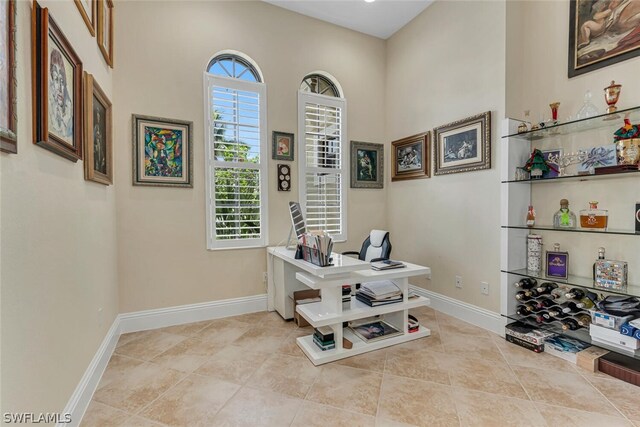 tiled home office featuring a high ceiling