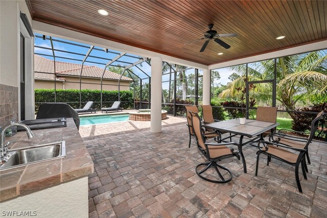 sunroom / solarium featuring ceiling fan, sink, and wood ceiling