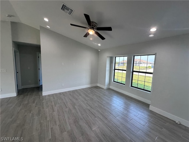 empty room with vaulted ceiling, ceiling fan, and dark hardwood / wood-style floors