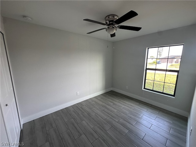 spare room with dark wood-type flooring and ceiling fan