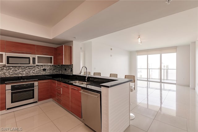 kitchen with light tile flooring, sink, stainless steel appliances, and kitchen peninsula