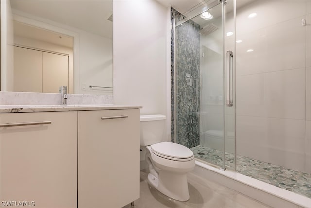 bathroom with tile floors, toilet, walk in shower, and vanity