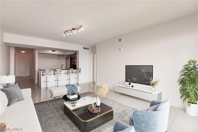 tiled living room featuring track lighting