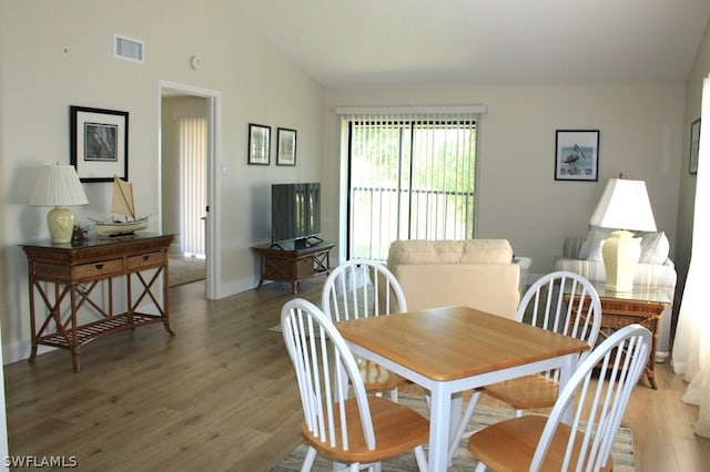 dining space with lofted ceiling and hardwood / wood-style floors