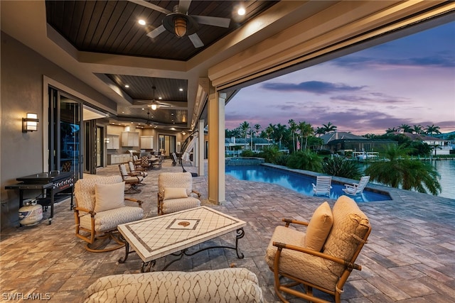 patio terrace at dusk featuring ceiling fan