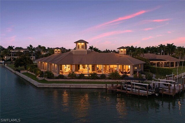 back house at dusk featuring a water view