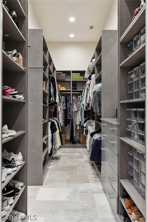 walk in closet with light tile floors