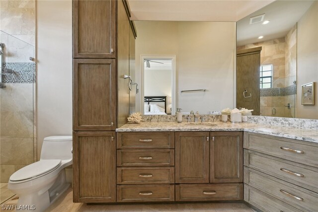 bathroom with walk in shower, tile walls, ceiling fan, toilet, and vanity